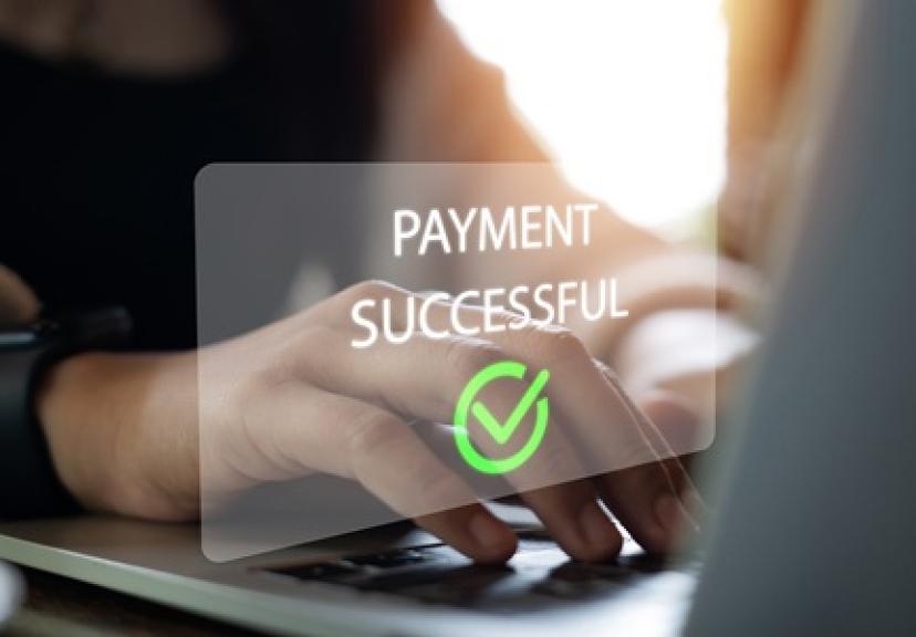 Sign reading "payment successful" over laptop keyboard