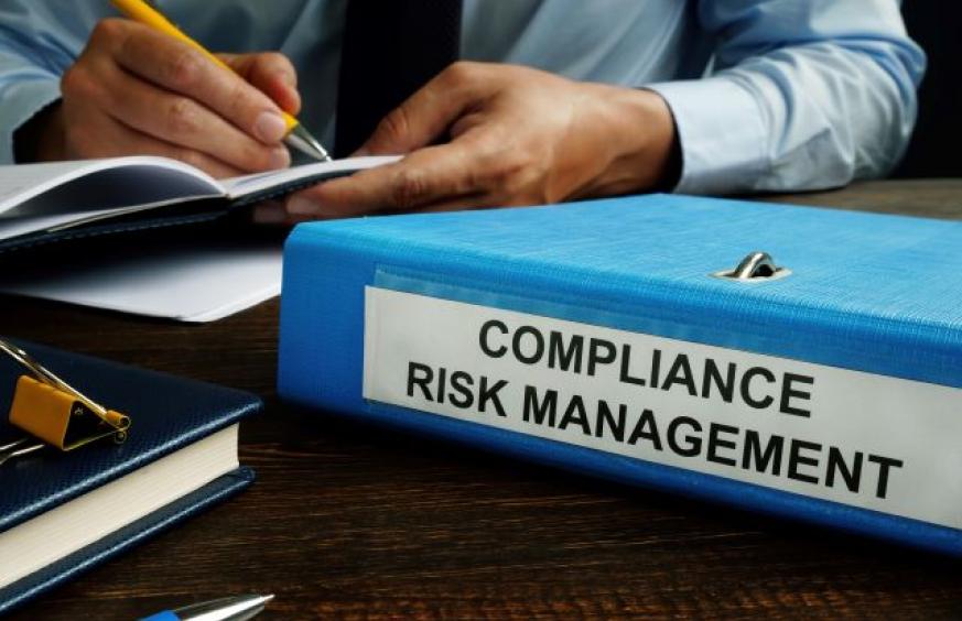 looseleaf with "compliance risk management" on it