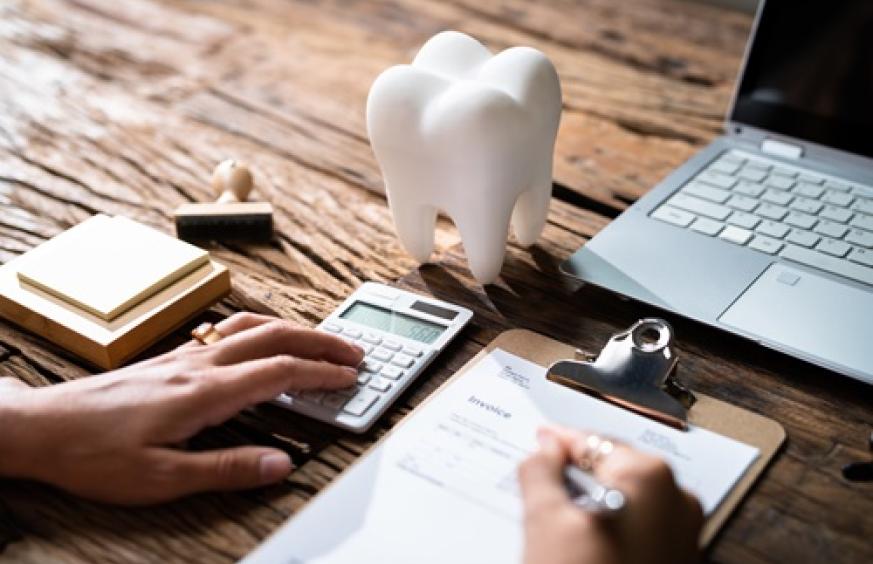 tooth with hand on calculator and writing an invoice