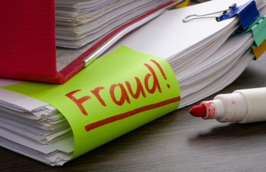 stack of papers with the word 'fraud' on them.
