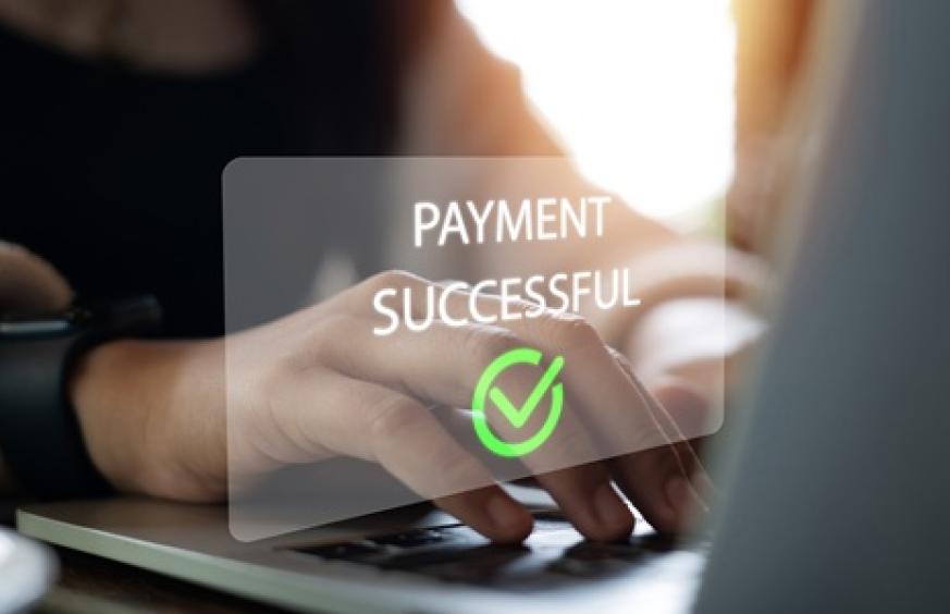 Sign reading "payment successful" over laptop keyboard