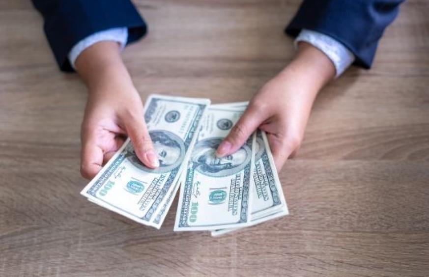 hands holding 100 dollar bills