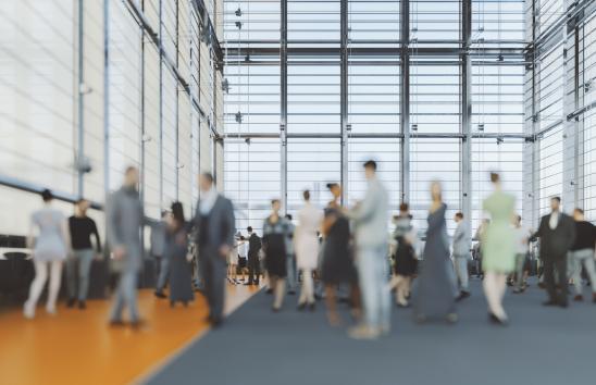 blurry image of guests in a large space talking