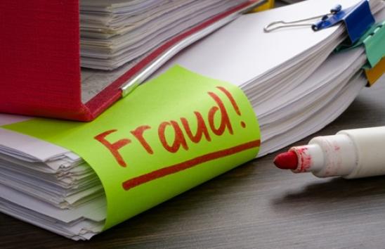 stack of papers with the word 'fraud' on them.