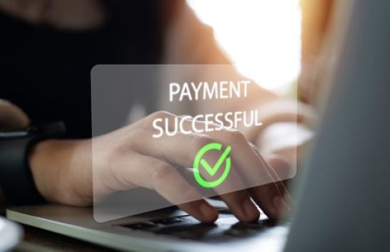 Sign reading "payment successful" over laptop keyboard