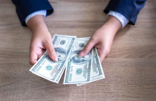 hands holding 100 dollar bills